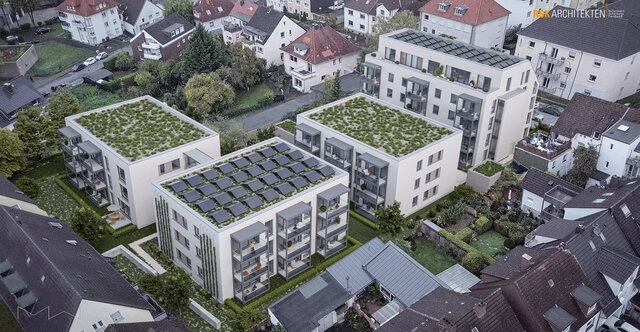 Vogelperspektive auf vier Gebäude mit Dachbegrünung und Solarpanelen