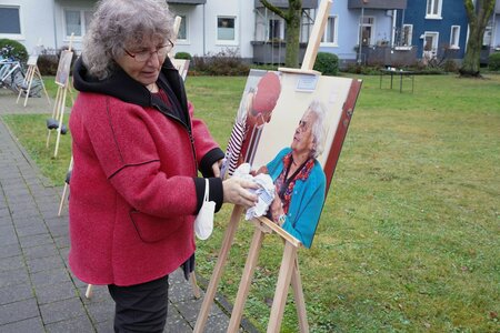 Fotografin befreit Ausstellungsfotos von Regenwasser mit Tuch