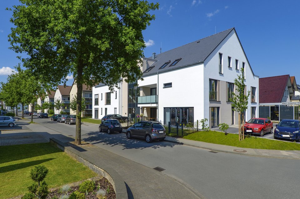 Mehrfamilienhaus dreigeschossig, weiße Außenfassade, graues Dach