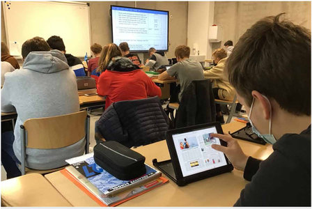 Schuler in einem Klassenraum lesen via Tabletts in der Tageszeitung Neue Westfälische