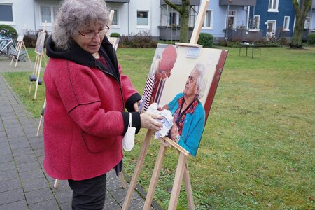 Fotografin befreit Ausstellungsfotos von Regenwasser mit Tuch