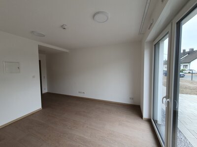 Helles, lichtdurchflutetes Zimmer mit großem Fenster und weißen Wänden