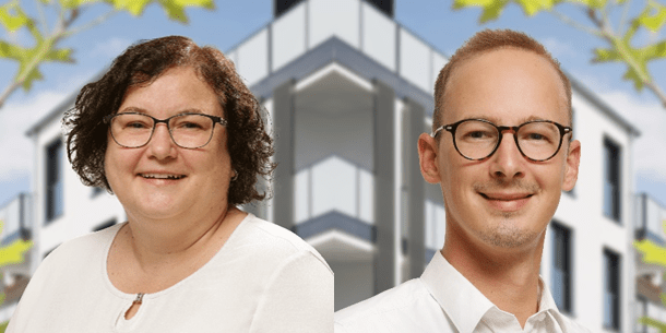 Frau mit Brille und mittellangen, lockigen Haaren in weißer Blus und junger Mann mit Brille und weißem Hemd vor einem modernen Gebäude.