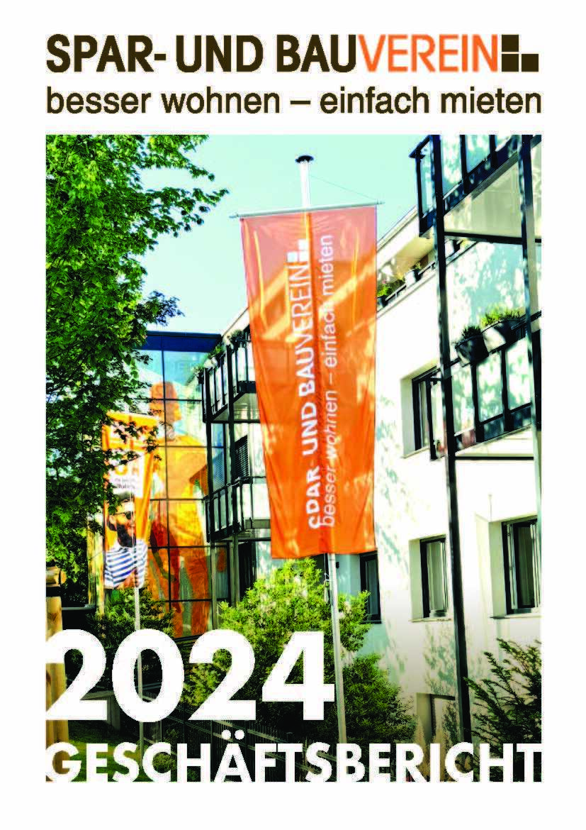 Zwei orange Fahnen vor einem Gebäude mit einem Baum